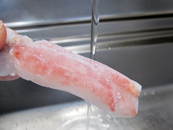 ズワイガニポーション　蟹を流水で解凍した写真